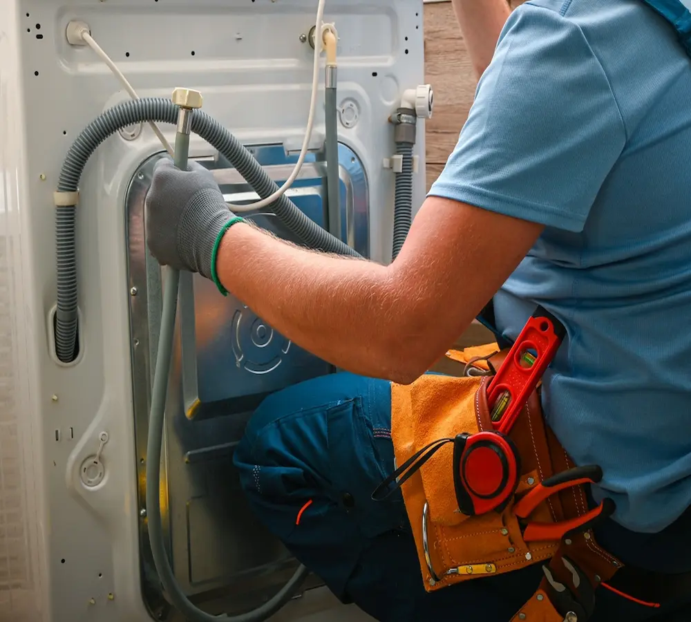 tecnico conectando la lavadora a la toma de agua